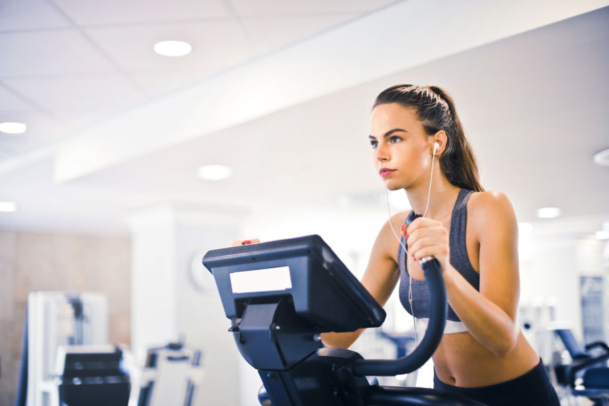 Member training on cardio equipment in a bright fitness studio