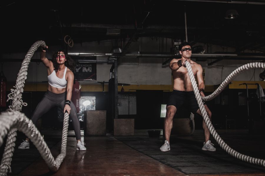 Coach guiding a member through a strength exercise